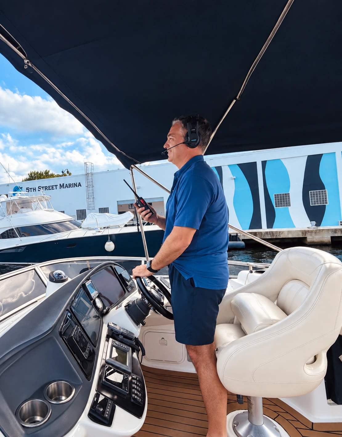 Captain Javier at the helm using a handheld radio and communication headset